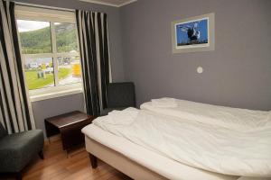 a hotel room with a bed and a window at Ulvsvåg Gjestgiveri og Fjordcamping AS in Ulvsvåg