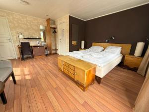 a bedroom with a large bed and a table at Ulvsvåg Gjestgiveri og Fjordcamping AS in Ulvsvåg
