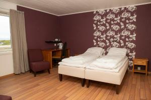 a room with a bed and a desk and a chair at Ulvsvåg Gjestgiveri og Fjordcamping AS in Ulvsvåg