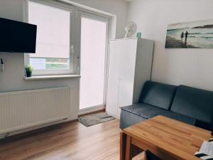 a living room with a couch and a window at Pokoje Gdańska Wyspa in Gdańsk
