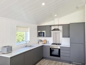 a kitchen with gray and white appliances and a window at Cherry Blossom 38 Hot Tub in Garton