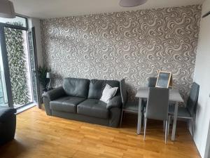 a living room with a couch and a table at 2 Bedroom Apartment - Henry St Central Liverpool in Liverpool