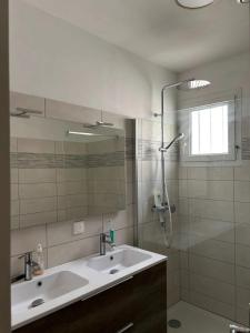 a bathroom with a sink and a shower at Maison charmante avec balcon près de Foulerot - 85 m² in Saint-Georges-dʼOléron