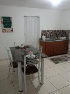 a kitchen with a table and chairs and a kitchen with a counter at No jardim in Pomerode