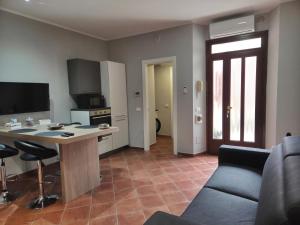 a kitchen and living room with a table and a couch at Cà Fiamma 3 in Casale Monferrato
