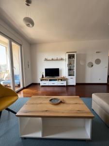 a living room with a coffee table and a tv at Sargo Apartman Bar in Bar +39 photos