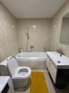 a bathroom with a toilet and a sink and a tub at Sargo Apartman Bar in Bar