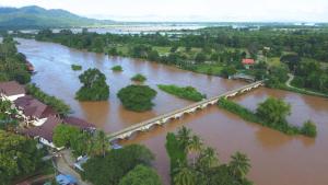 an aerial view of a river with a train on a bridge at souksanh River Bungalow in Along
