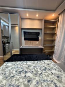 1 dormitorio con 1 cama, TV y estanterías en Studio CARIOCA, en Río de Janeiro