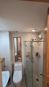 Un baño con inodoro y ducha de cristal. en Ohana Suites 2 Studio Lot 8 Condo Near Ayala Cebu City with fast Wifi and Netflix, en Cebú 16 fotos más