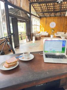a laptop computer sitting on a table with a plate of food at Pousada Barra do Sahy in Barra do Sahy