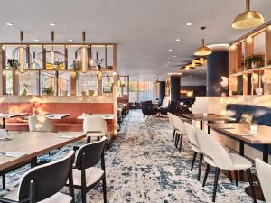 a restaurant with tables and chairs in a room at Crowne Plaza Bratislava by IHG in Bratislava
