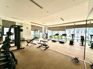 a gym with several treadmills and elliptical machines at Deluxe Studio Next National Convention Centre And Marriott Hotel in Hanoi