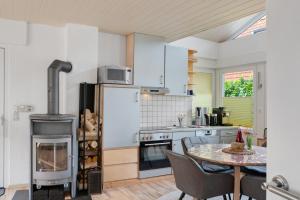 a kitchen with a stove and a table with chairs at Haus Lotte in Wittmund