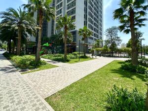 a brick walkway with palm trees in a park at Deluxe Studio Next National Convention Centre And Marriott Hotel in Hanoi