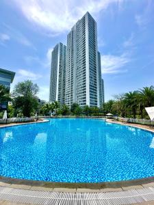 a large blue swimming pool with tall buildings in the background at Deluxe Studio Next National Convention Centre And Marriott Hotel in Hanoi