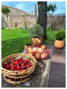 two baskets of fruit sitting on a table at House Perigourdine ex former diligence relay in Falgueyrat