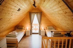a room with two beds in a wooden house at PUŹNIAKÓWKA in Czarna
