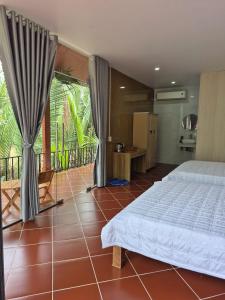 a bedroom with a bed and a balcony at Homestay Xóm Quê in Ấp Thành Hòa +125 photos