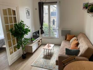 a living room with a couch and a table at Appartement 3 pers, métro direct in Aubervilliers