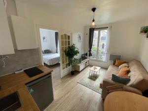 a living room with a couch and a table at Appartement 3 pers, métro direct in Aubervilliers