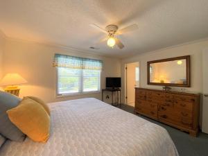 a bedroom with a bed and a dresser with a mirror at Dreamcatcher in Edisto Island