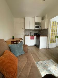 a living room with a couch and a kitchen at Appartement 3 pers, métro direct in Aubervilliers