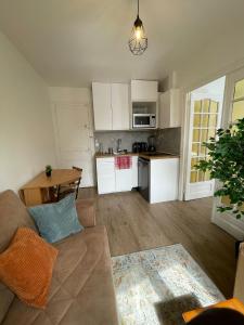 a living room with a couch and a kitchen at Appartement 3 pers, métro direct in Aubervilliers +38 photos