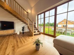 a large living room with a staircase and a television at Dom w Nowym Sztynorcie in Sztynort