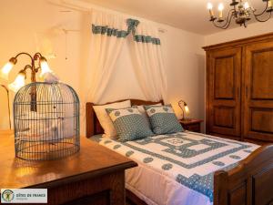 una camera da letto con un letto con una gabbia per uccelli su un tavolo di Le Pigeonnier du Mas de Salles a Lugan