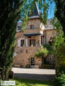 una vecchia casa in pietra con una scala di fronte di Le Pigeonnier du Mas de Salles a Lugan