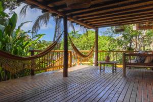 a hammock on the deck of a house at Pariri Suites in Trancoso