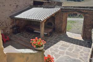 an outdoor patio with a bench and a pot of flowers at Le Mas de Jacquet in Saint-Izaire +35 photos