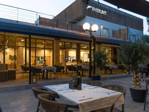 a restaurant with tables and chairs in front of a building at Zlatni Rat Beach Resort in Bol