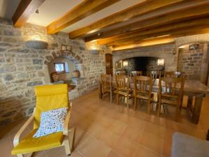 a kitchen and dining room with a stone fireplace at Gîte Le Valat in Peyreleau