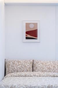 Un dormitorio con una cama con un cuadro en la pared. en Seoul Cozy Hostel, en Seúl