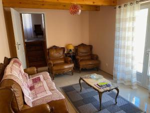 a living room with leather chairs and a coffee table at Les Tilleuls in Tréjouls