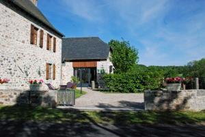 a stone house with two chairs in front of it at Gîte sur les hauteurs de l'Aubrac in Bouyssounouse