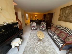 a living room with a couch and a piano at L'Ancienne épicerie in Canals