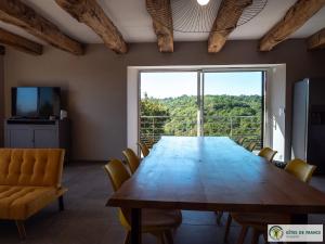 a large table in a room with a large window at Gite Le Sauvage in Sébrazac