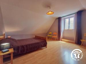 a bedroom with a bed and a window and two chairs at Marijolet in Saint-Laurent-dʼOlt