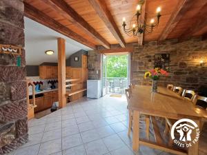 a kitchen with a wooden table and a dining room at Marijolet in Saint-Laurent-dʼOlt