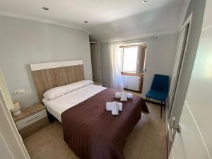 a bedroom with a bed with two towels on it at Casa O Curruncho 3000 in Vilagarcia de Arousa