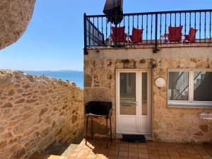 a building with a balcony with chairs and a door at Casa O Curruncho 3000 in Vilagarcia de Arousa