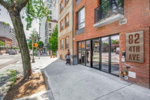 a woman standing on a sidewalk in front of a building at Blueground Boerum Hill rooftop nr Brooklyn Bridge NYC-1880 in Brooklyn