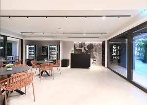 a dining room with tables and chairs and a tv at Icon Central SKG in Thessaloniki