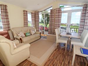 a living room with a couch and a table at Cody Lodge in Ilfracombe