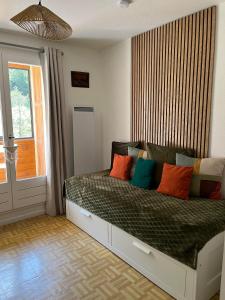 a bedroom with a bed with colorful pillows on it at Le flocon in Allos