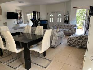 a dining room with a black table and white chairs at ANDRIA'S luxury family studio near Casino limassol in Limassol
