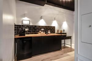 una cucina con mobili neri e un piano di lavoro di Hounslow Central Studio Aparments a Hounslow Altre 7 foto
